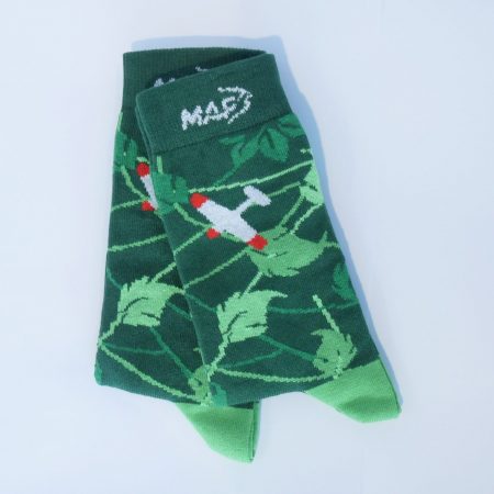 Een groene sok met een junglebladeren patroon. Op de enkel staat een MAF-vliegtuig.